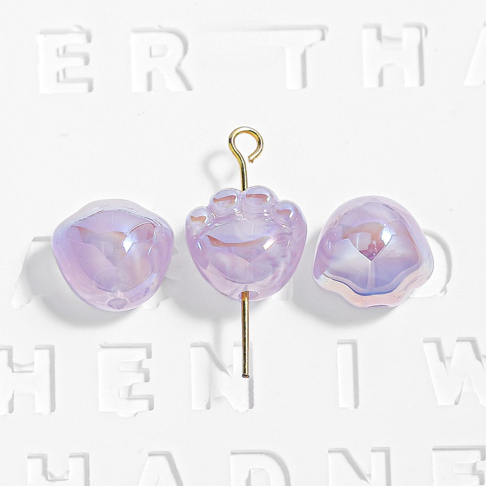 Three purple translucent paw-shaped beads, one on a gold eye pin