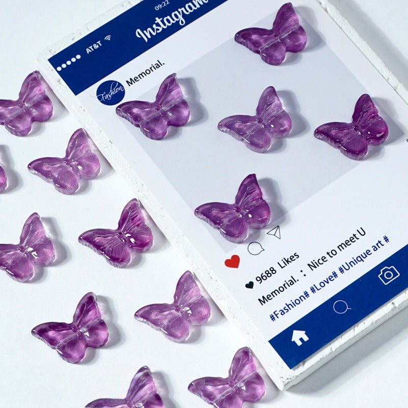 Translucent purple butterfly-shaped glass beads on a white surface beside a phone mockup