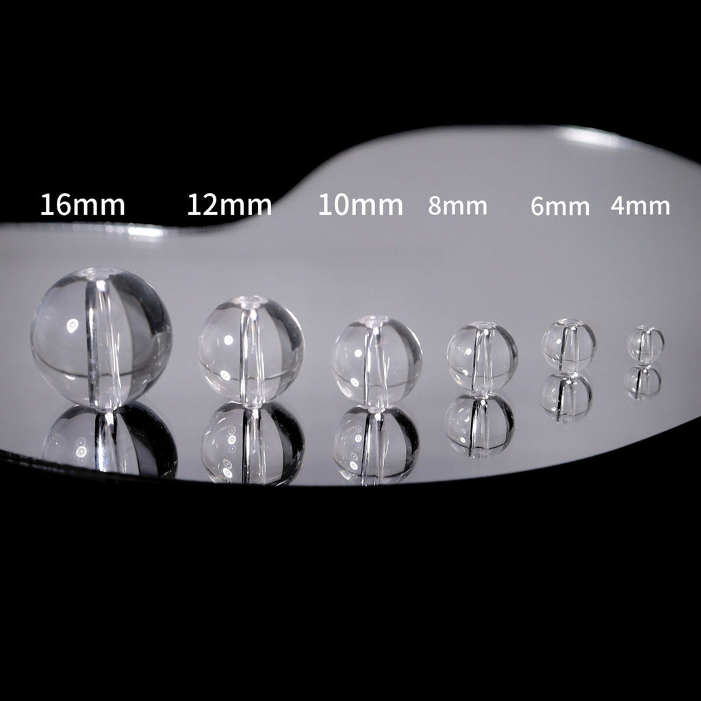 Clear glass sphere beads in descending sizes 16mm to 4mm on glossy surface
