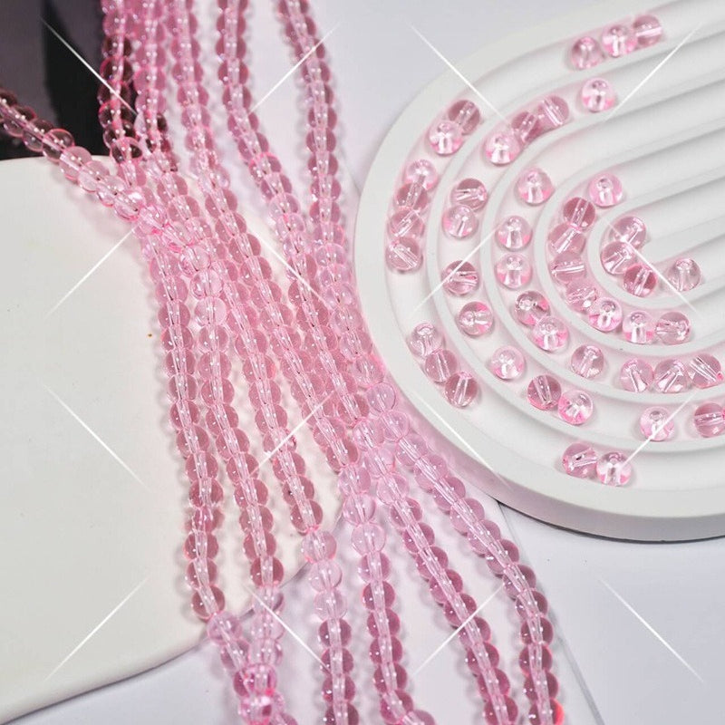 Pink faceted glass beads on white display stand, strands draped over