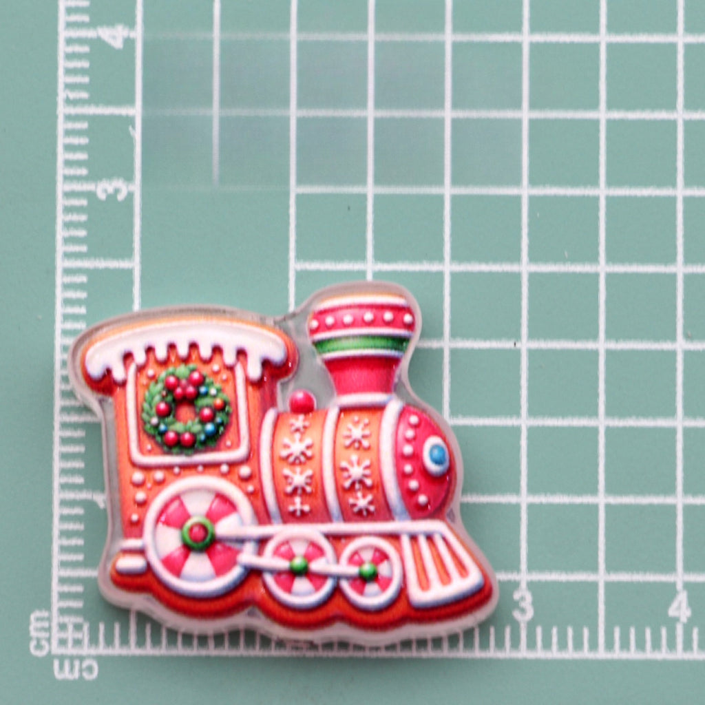 Gingerbread Christmas train acrylic charm in red with wreath and snowflakes on green cutting mat