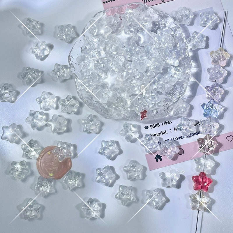 Clear star-shaped glass beads scattered on a white surface