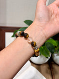 Golden tiger's eye bead bracelet with mantra spacer beads worn on a wrist