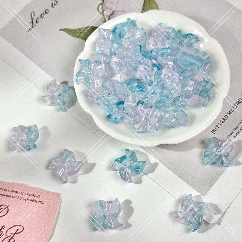 Translucent pastel 20mm carved glass windmill beads in soft blue, lavender and pale aqua in a white scalloped dish