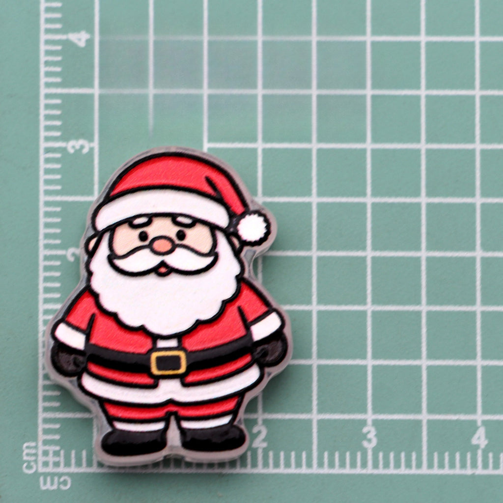 Cartoon Santa Claus acrylic charm with red hat and white beard on green cutting mat