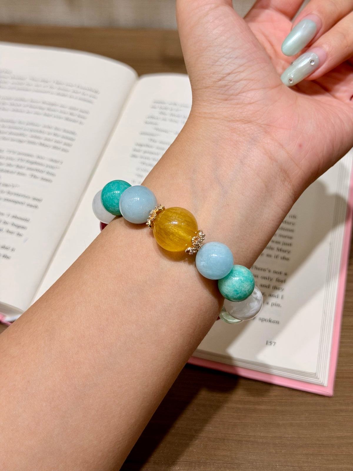 Woven Sea Reverie bracelet on wrist — aquamarine, amazonite, golden silky fluorite focal, rhodonite and snowflake phantom quartz beads