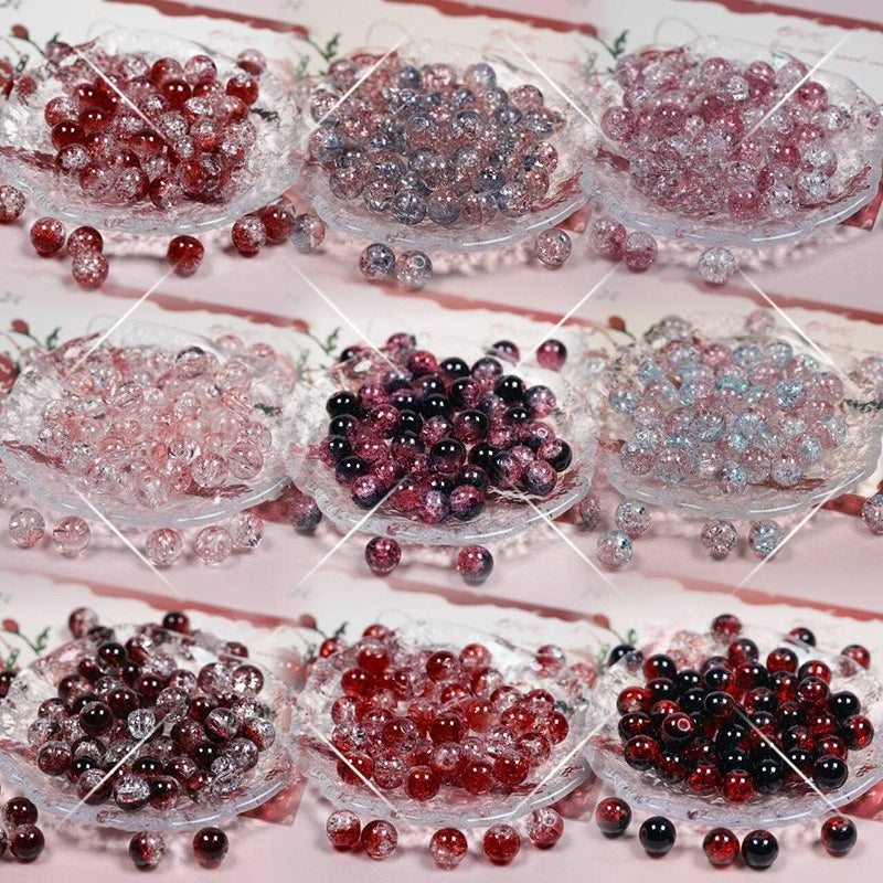 Nine glass bowls filled with decorative red, pink, purple, and black round beads, arranged in a grid on a light pink background with a white diagonal watermark overlay.