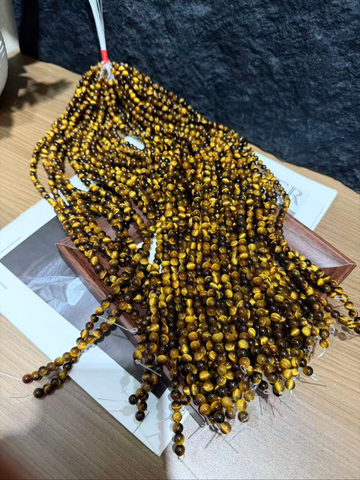 Multiple strands of yellow tiger's eye beads fanned out on a display tray