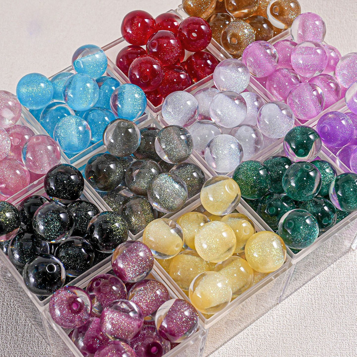 Organizer tray of round translucent glitter beads in assorted colors on light fabric