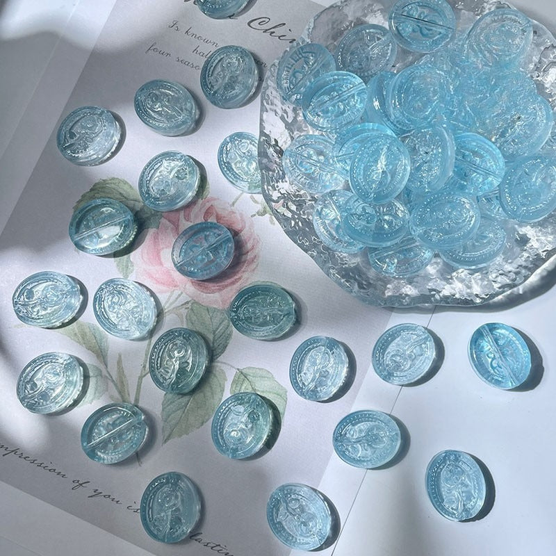 Light blue translucent engraved glass rose beads scattered on white