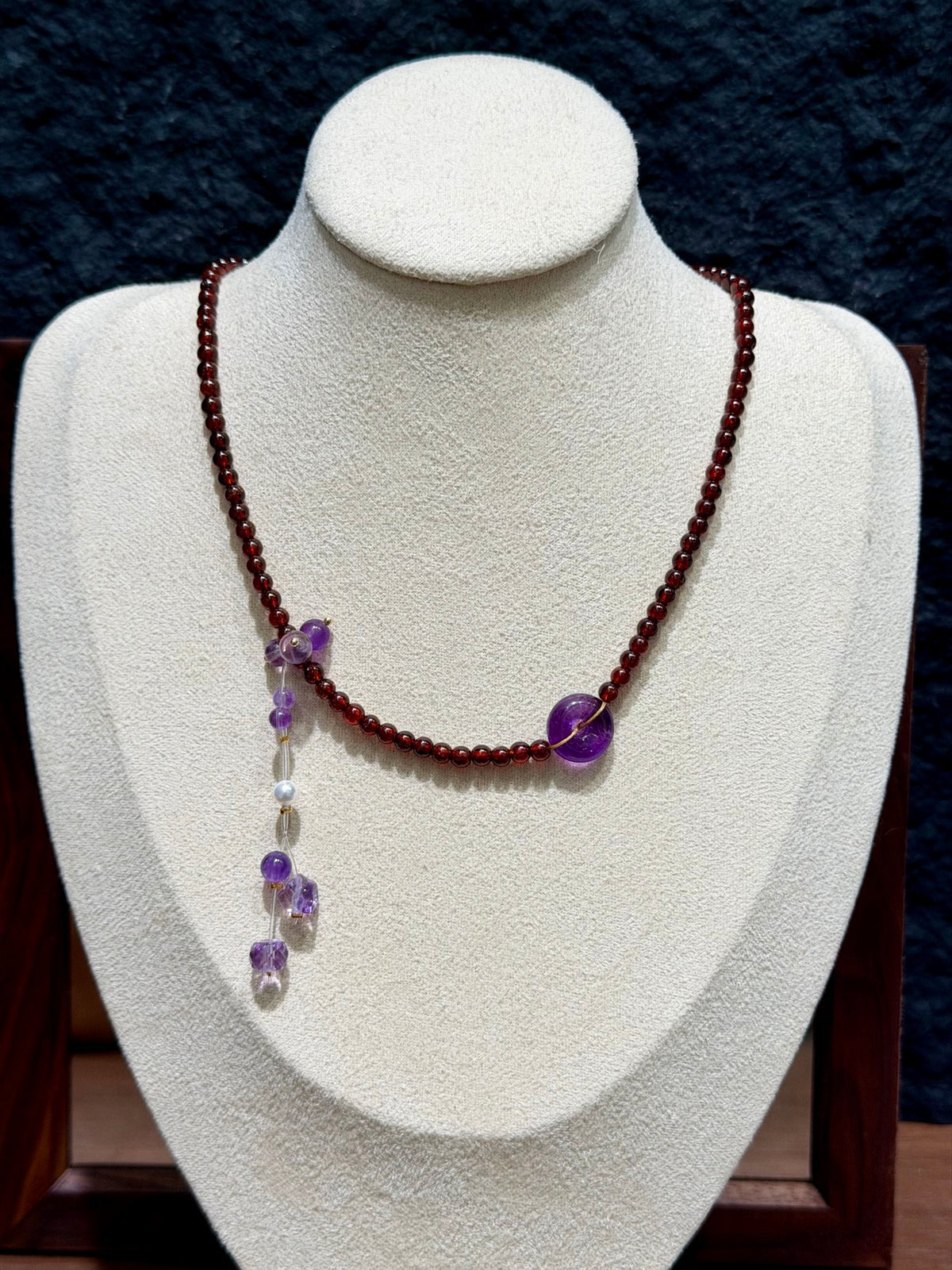 Garnet & Amethyst Peace Buckle Necklace on display bust
