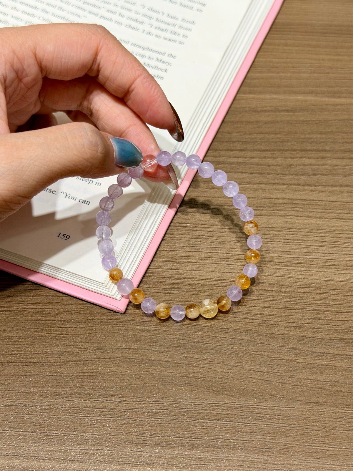 Lavender Amethyst & Citrine Bracelet held over open book