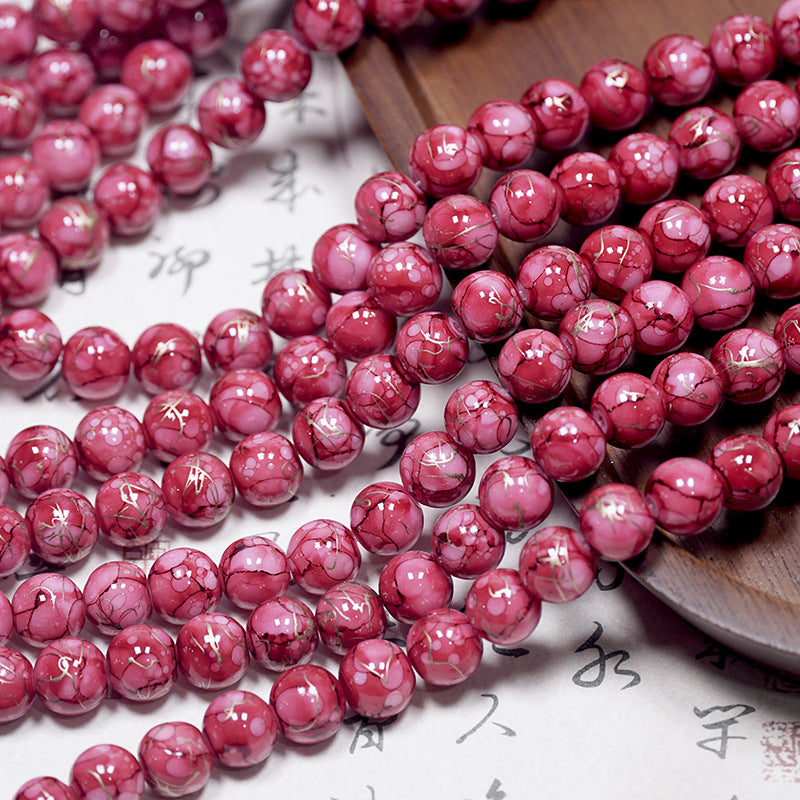 Close-up of pinkish-red marbled porcelain bead strands with light marbled streaks