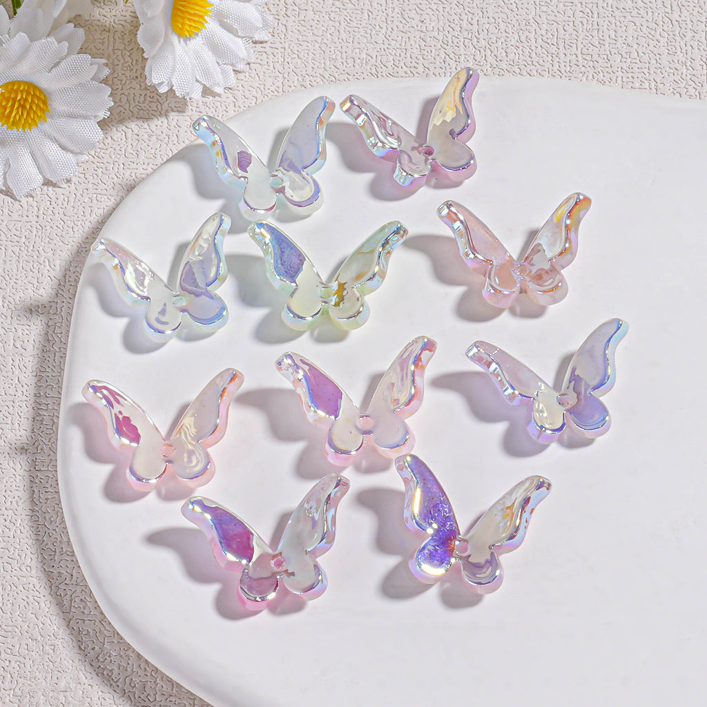 Nine iridescent butterfly acrylic beads on white plate with white daisies