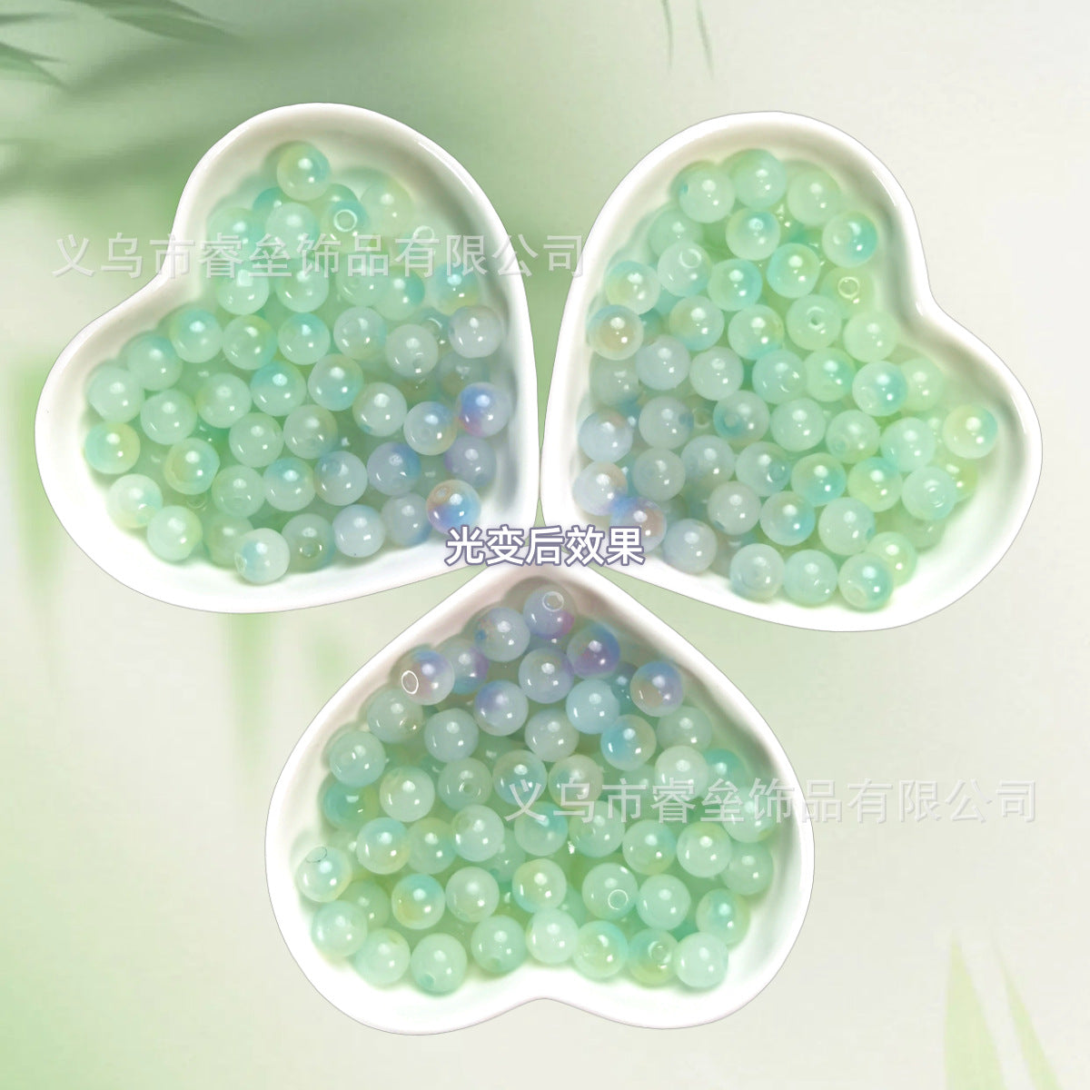 Three heart-shaped dishes of iridescent pale green and mint beads on light green