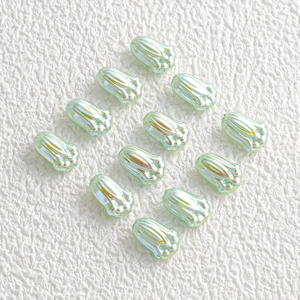 Twelve small iridescent mint green and yellow glass beads in a loose diagonal line