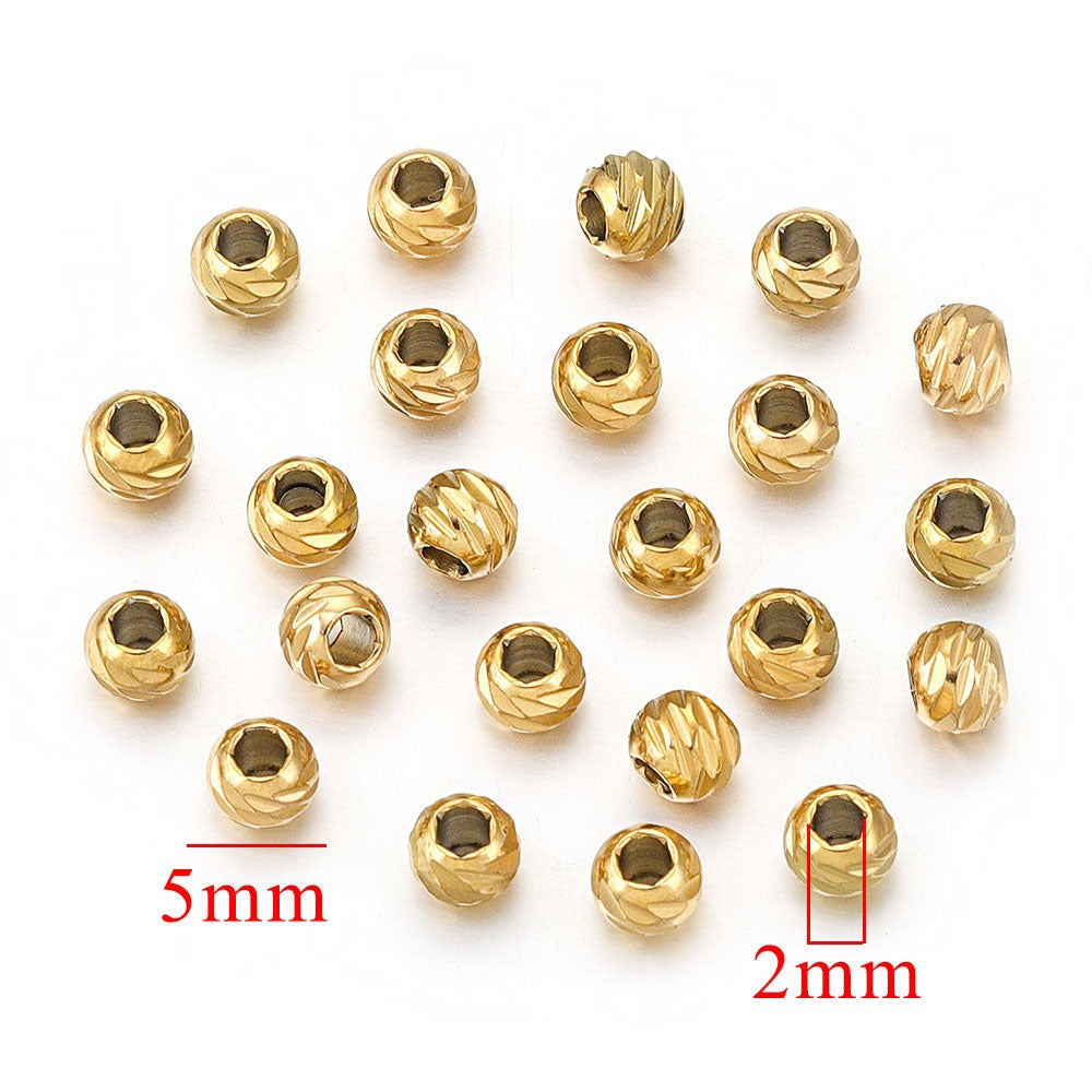 Gold-plated diamond-cut stainless steel wheel spacer beads with measurement indicators on white background