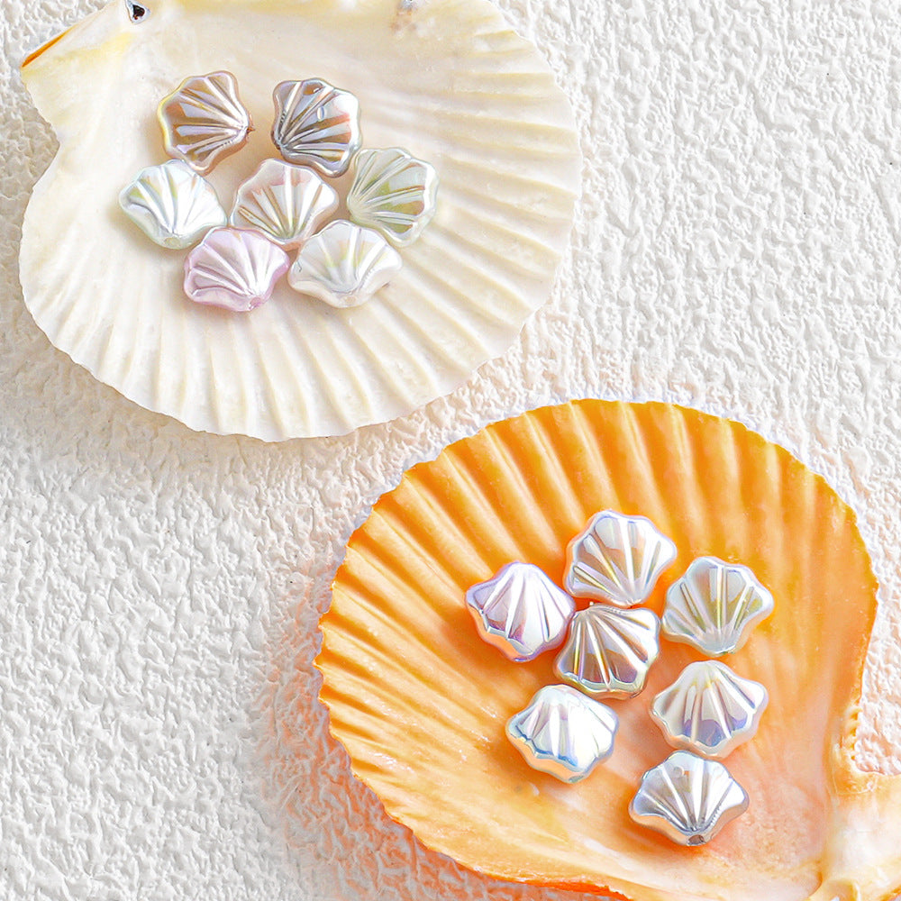 Iridescent shell-shaped faux pearl beads arranged on two scallop shells