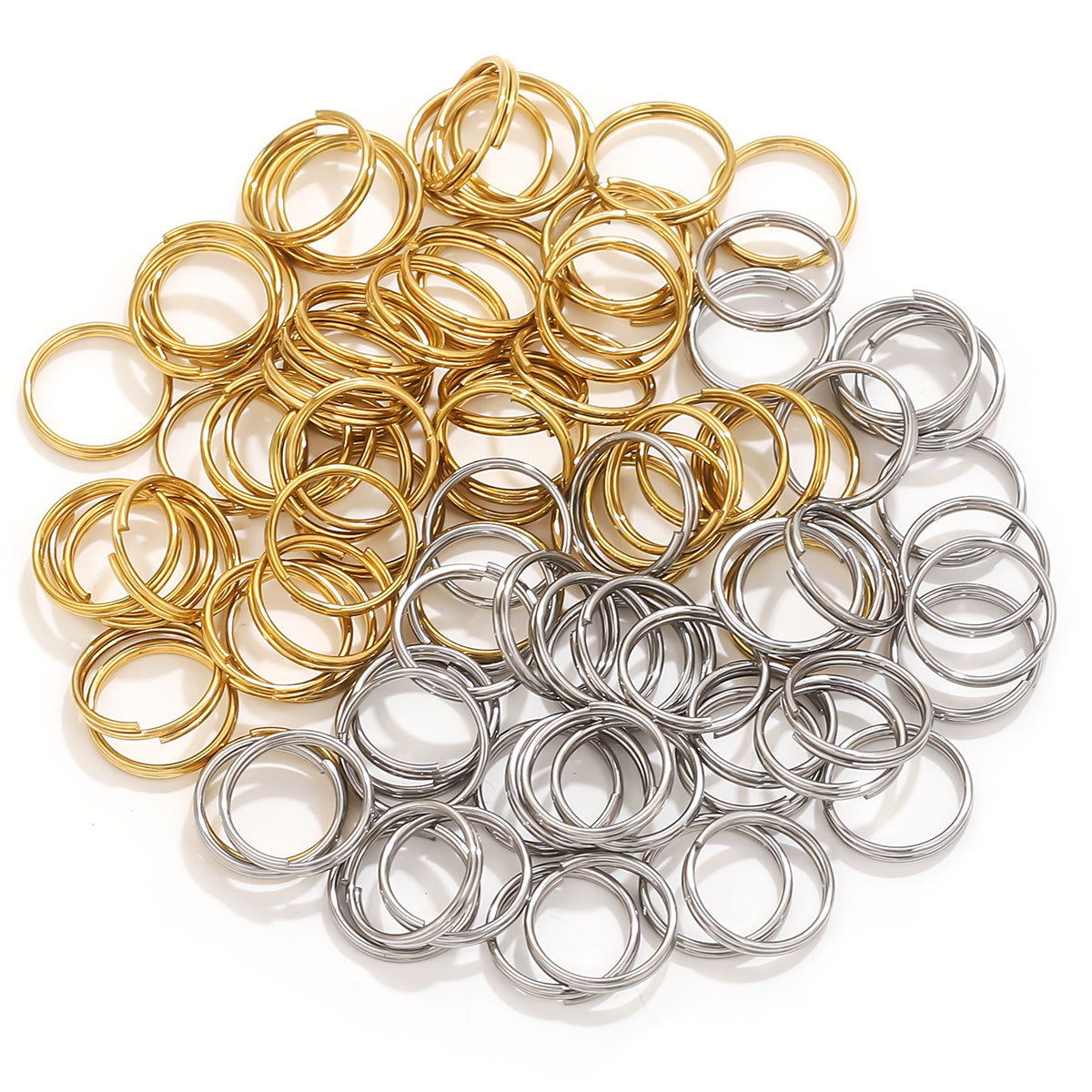 Small gold and silver split rings piled together on white background
