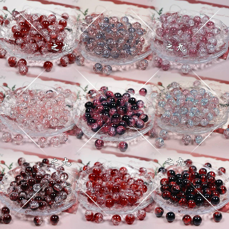 Nine glass bowls of assorted red, pink, purple, black, and clear beads in a 3x3 grid
