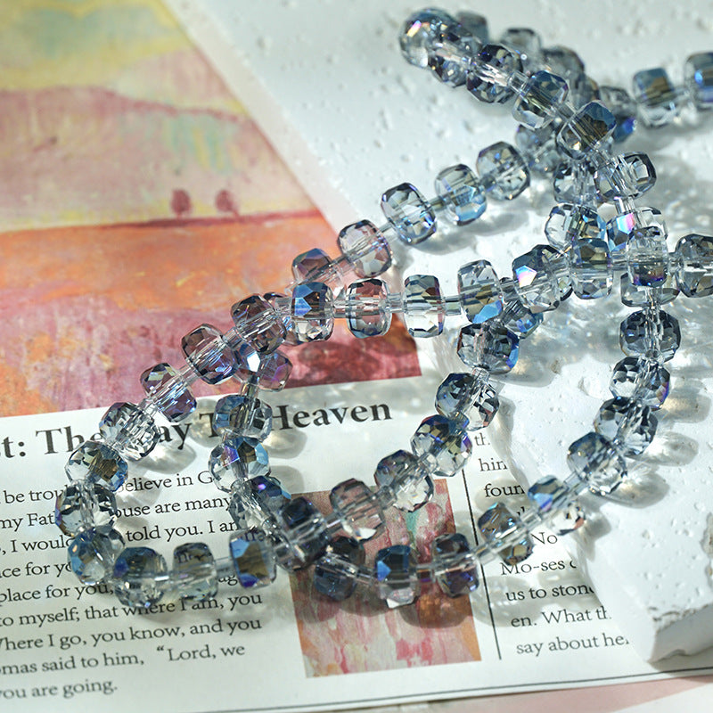Clear faceted glass beads with a light blue tint, arranged in a loose circle on top of a printed book page.