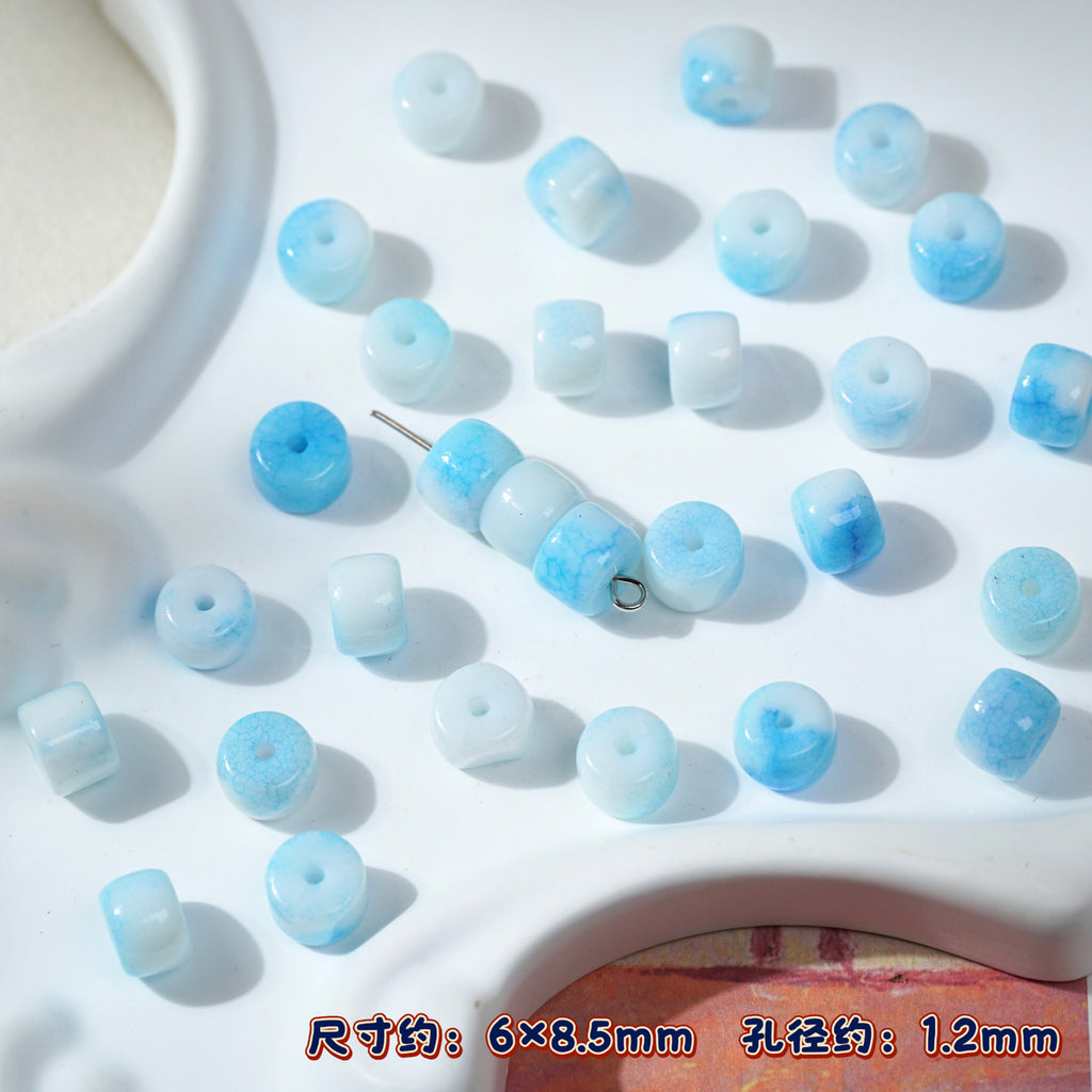 Light blue and white marbled cylindrical porcelain beads on white, metal pin