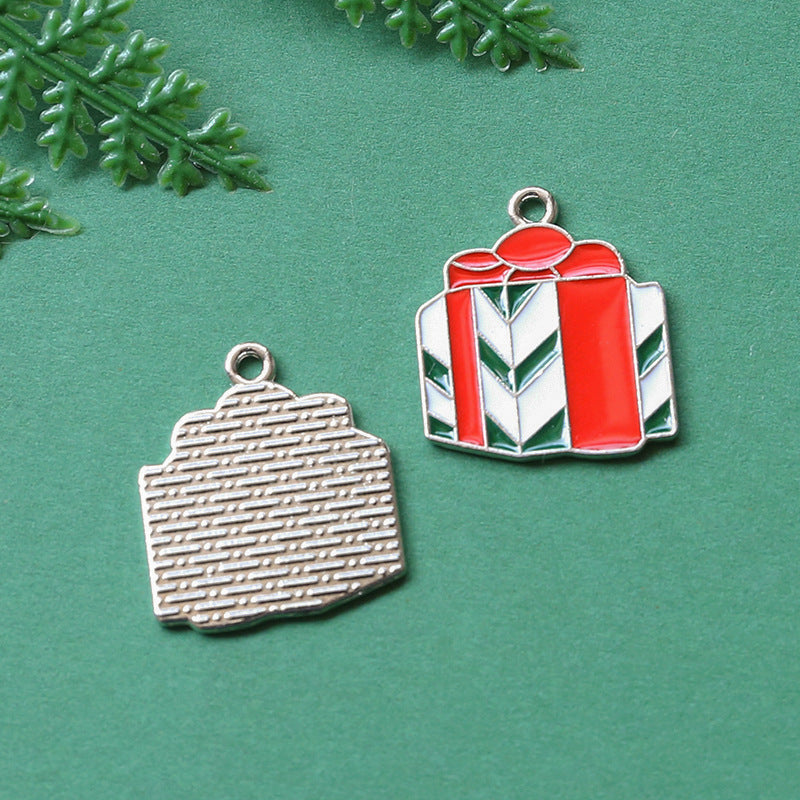 Two gift box charms on textured green background, silver-toned