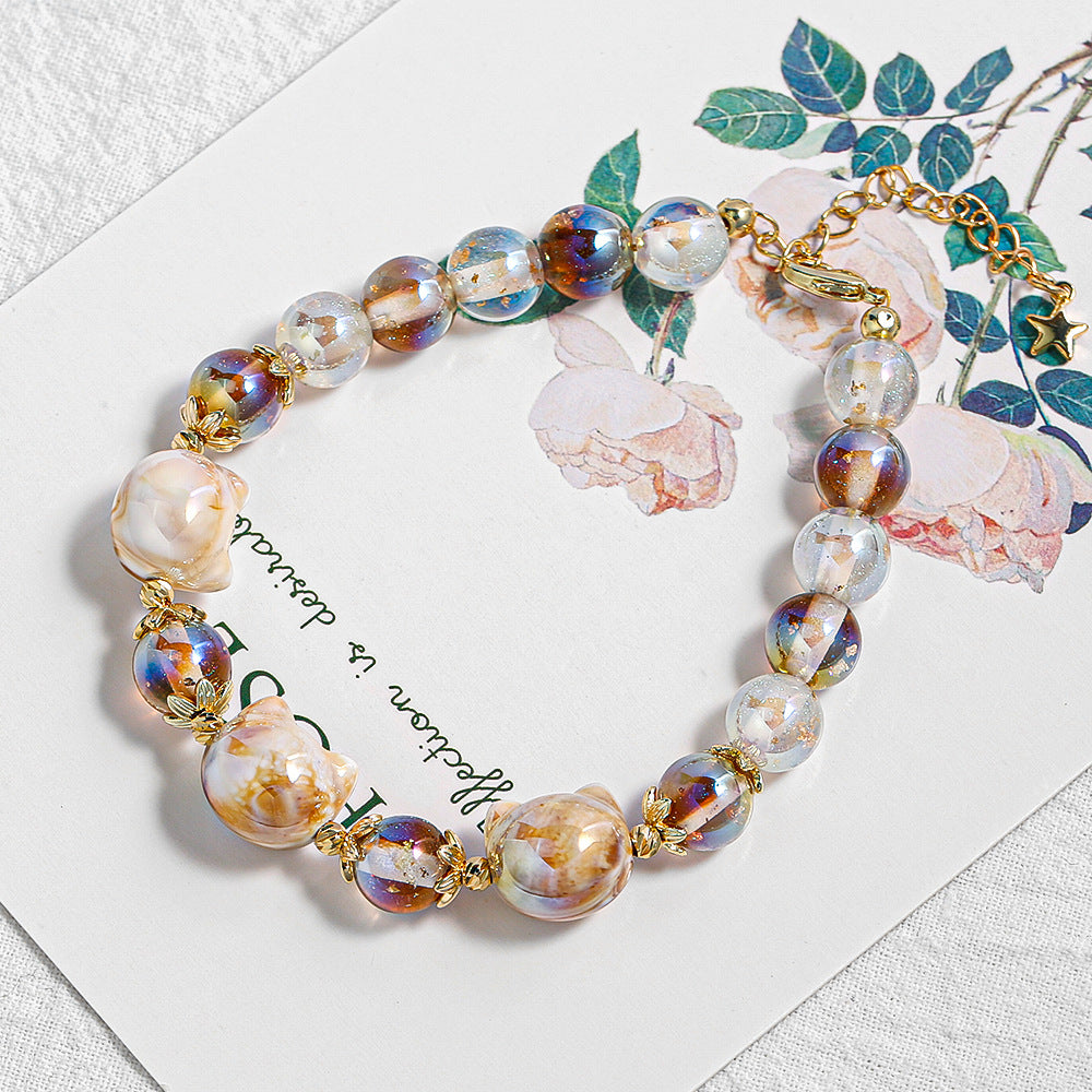 Beaded bracelet with iridescent clear beads and brown and gold marbled patterns.