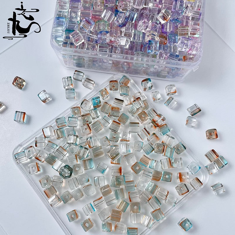 Two clear containers of assorted iridescent square crystal glass beads