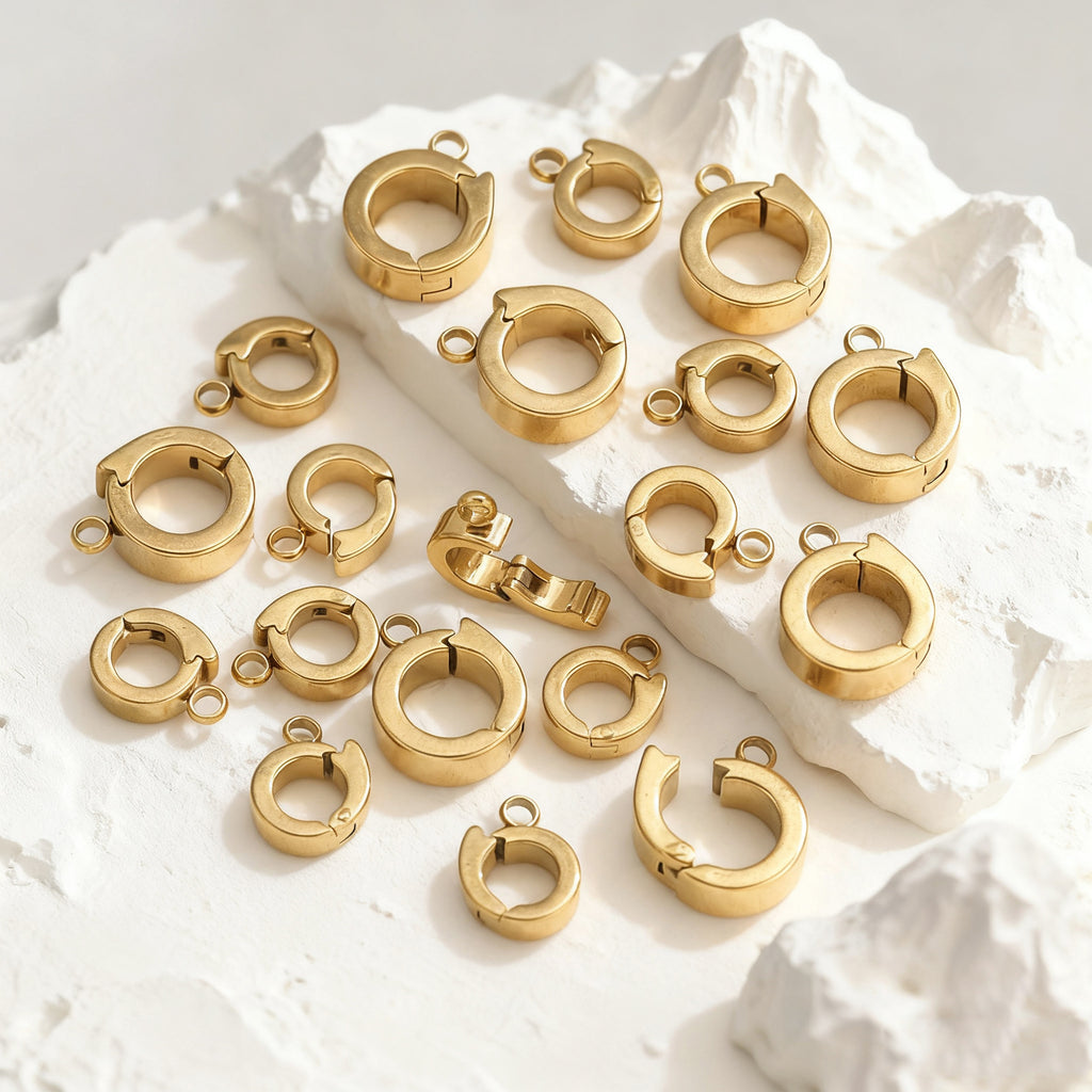 Gold open-ring connector clasps scattered on a white background