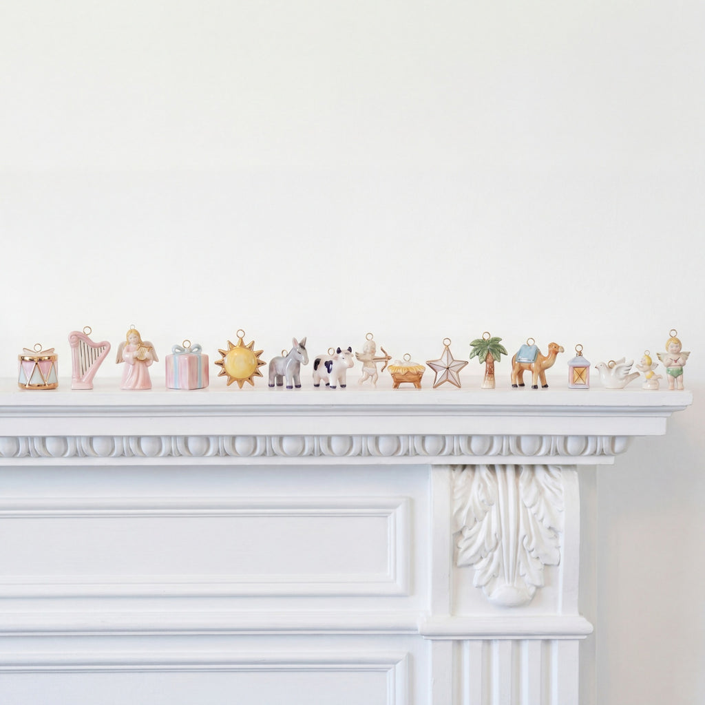 Decorative figurines on a white mantelpiece against a white wall