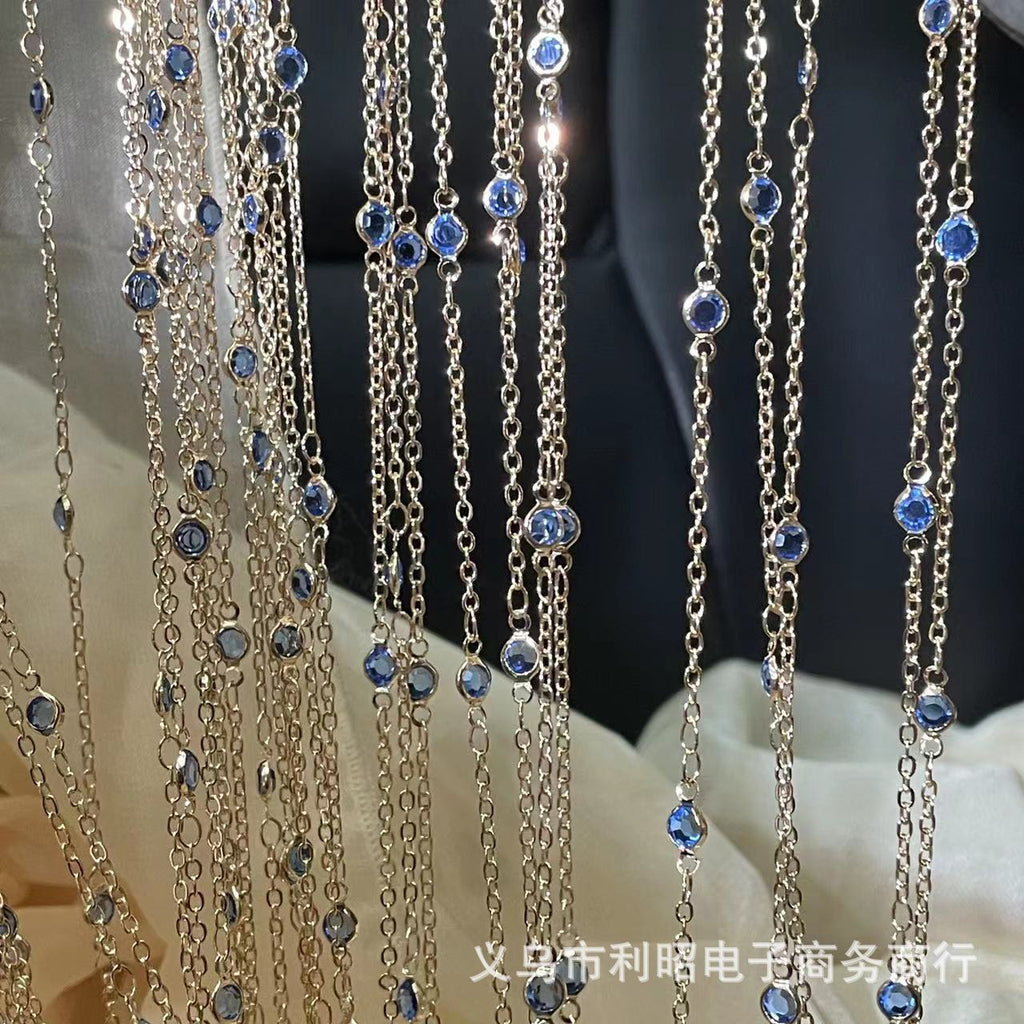 Silver-toned beaded chain strands with small light blue gemstones hanging vertically
