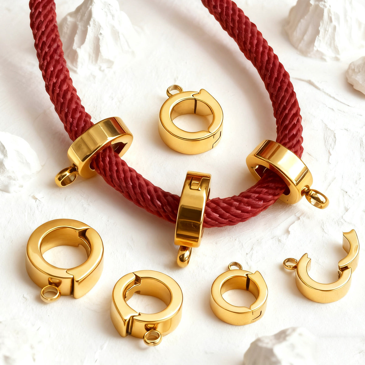 Gold stainless steel open-ring connector clasps on a red cord