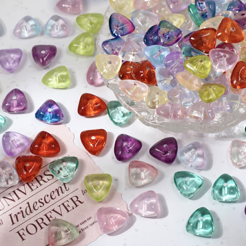 Heart-shaped iridescent glass beads in pink, purple, blue, green and orange on white, some in a clear glass dish