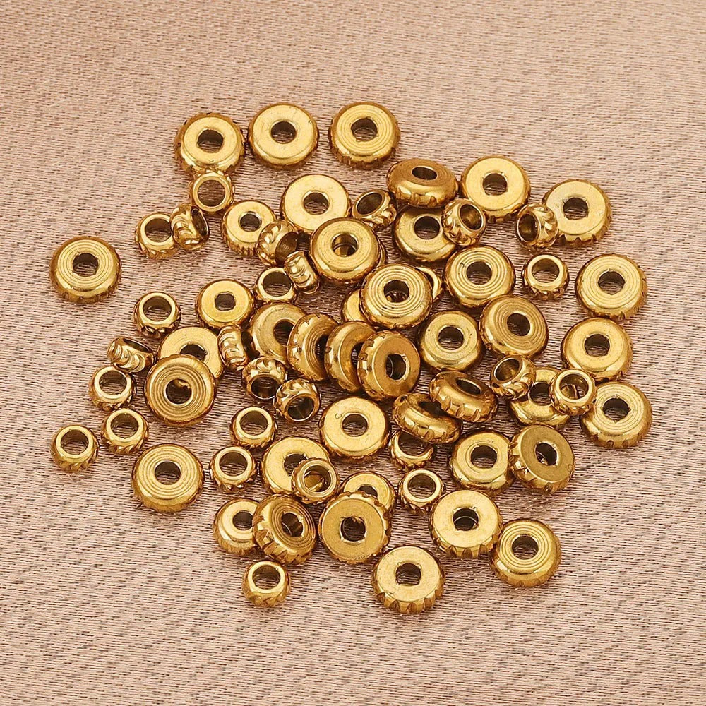 Gold-plated diamond-cut stainless steel abacus spacer beads on a beige background