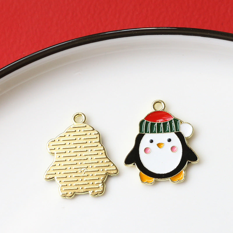 Two small enamel penguin charms on white plate with red background