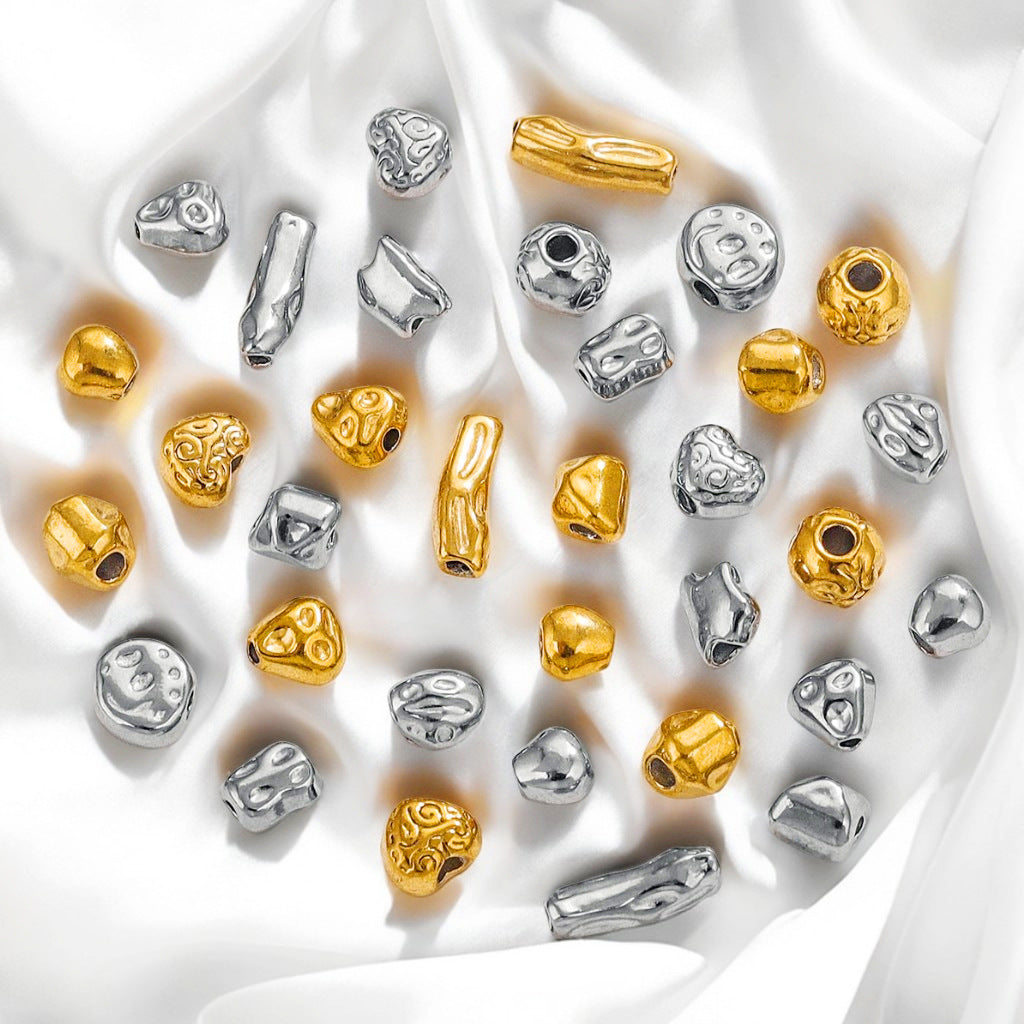 Baroque irregular stainless steel spacer beads in gold and steel finishes on white fabric