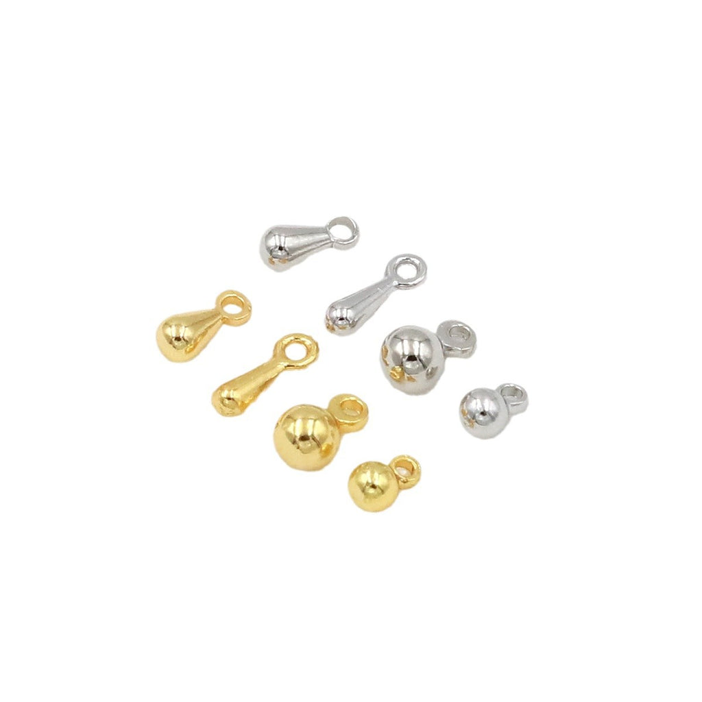 Gold and silver ball and teardrop charms with spring rings on a white background