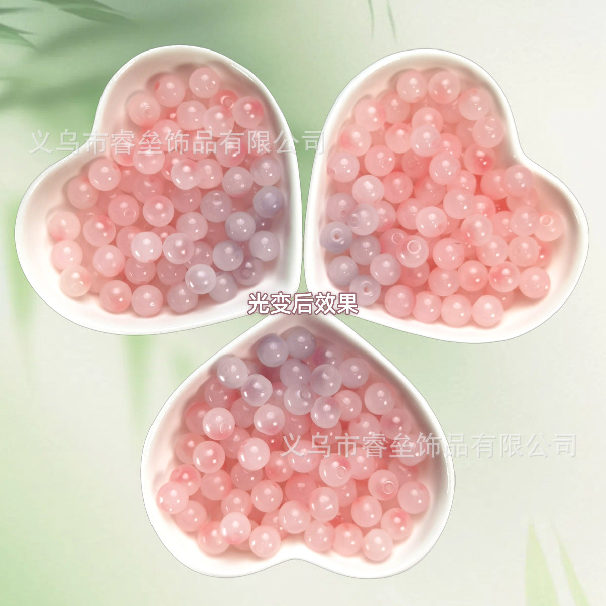 Three heart-shaped bowls of translucent pink beads on a pale green background