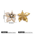 Two gold-toned flower pendant charms, one with black and white enamel petals and pearl center, 32mm by 32.3mm