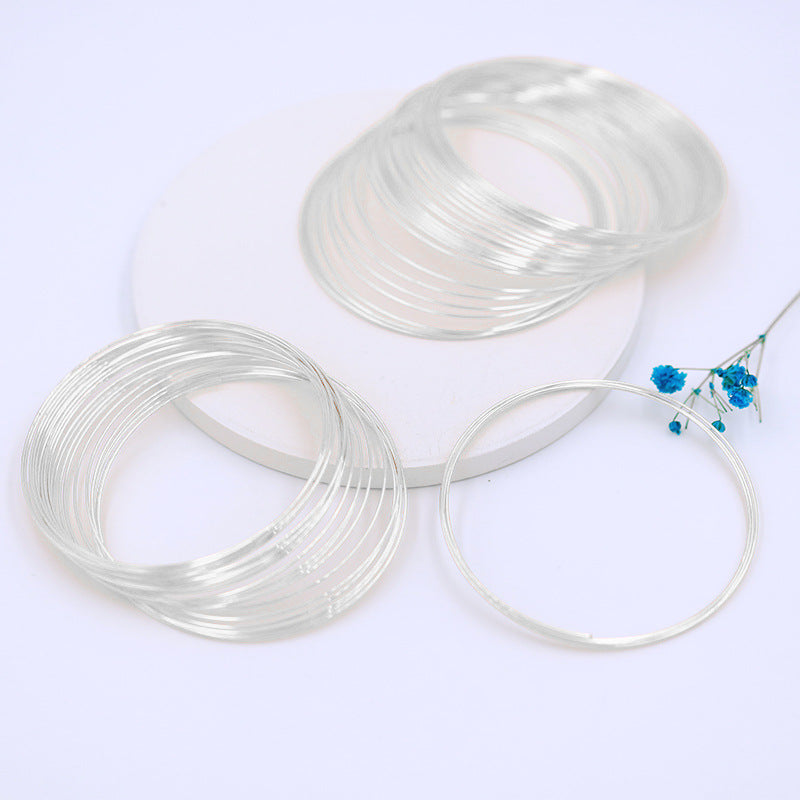 Clear transparent memory wire bracelet rings, coiled stacks with single loop, blue flower sprig