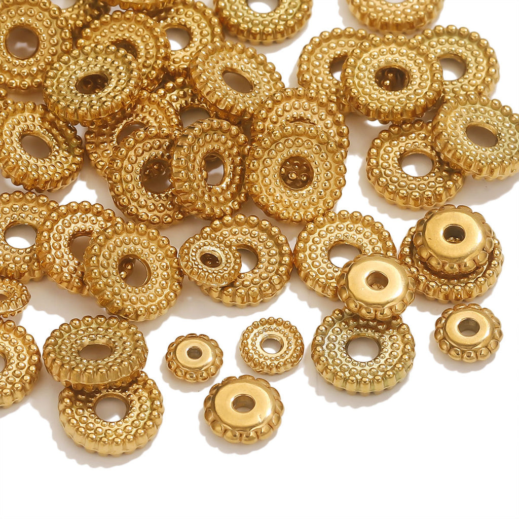 Pile of small gold-plated dotted gear wheel stainless steel spacer beads with hollow centers