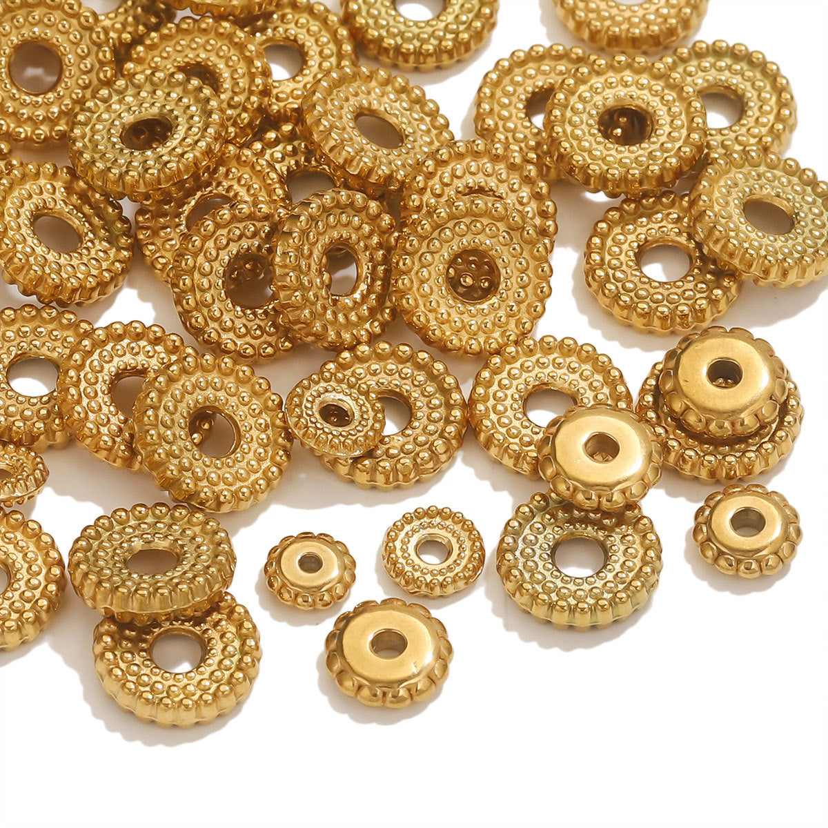 Pile of small gold-plated dotted gear wheel stainless steel spacer beads with hollow centers