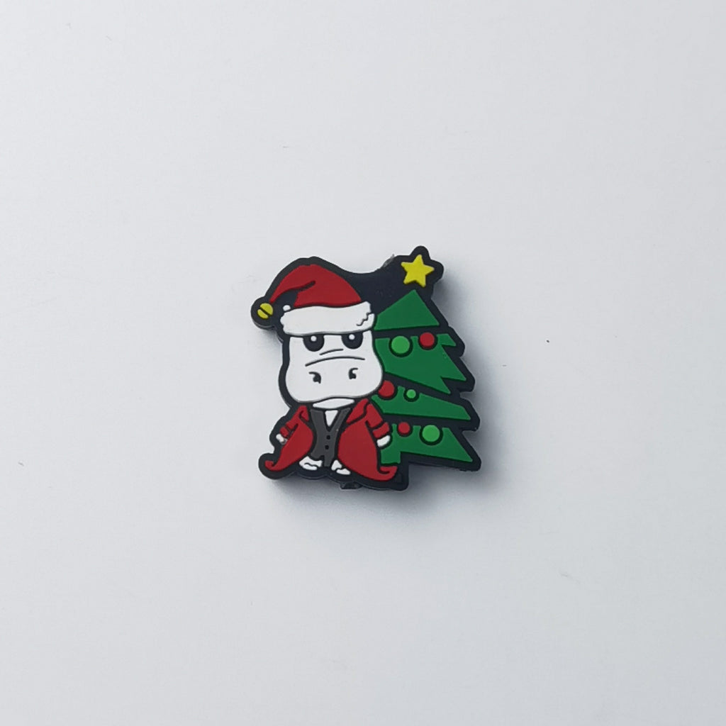 White hippo silicone focal bead wearing red Santa hat and red coat, standing by green Christmas tree with yellow star