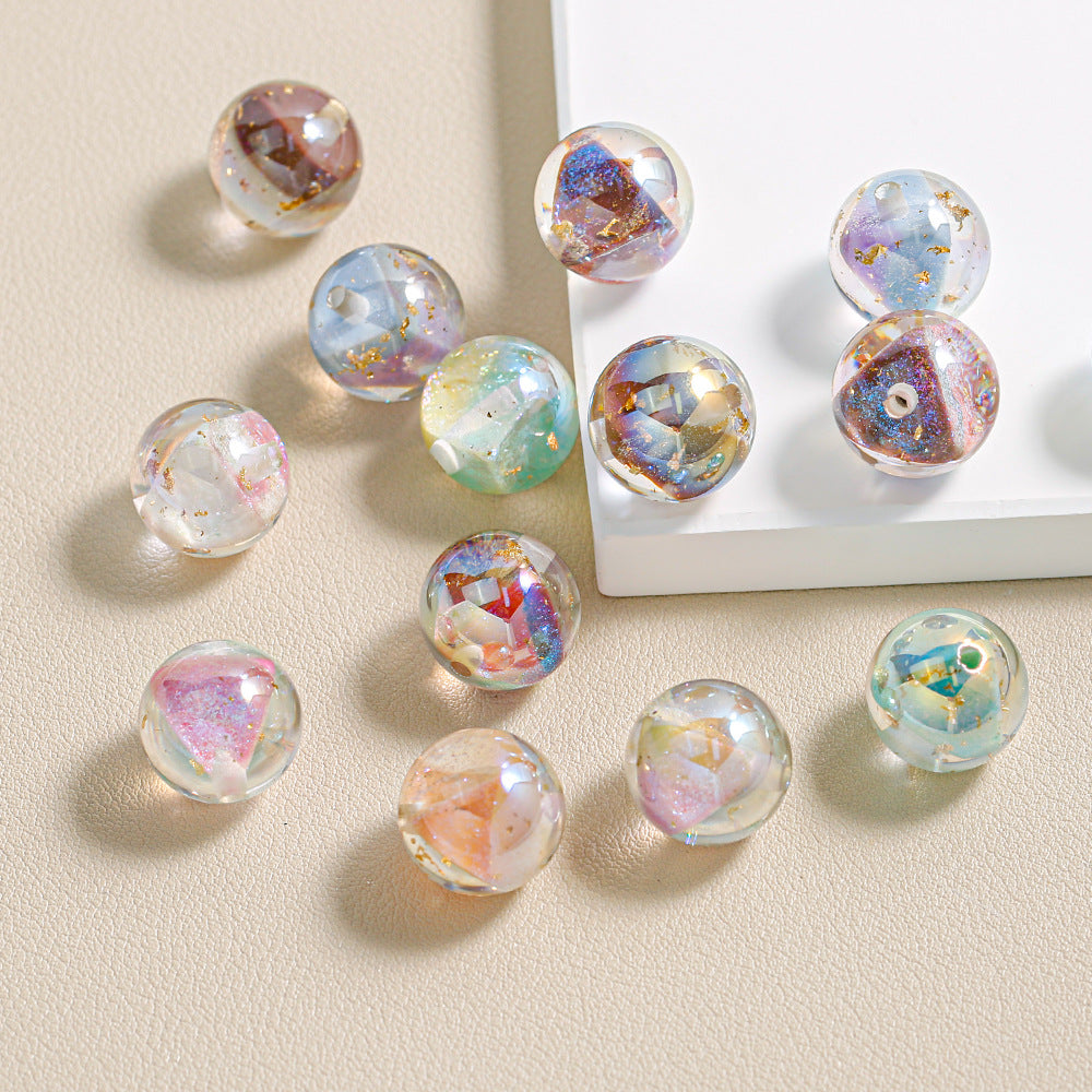 Multicolored resin beads on a beige surface with a white rectangular object.