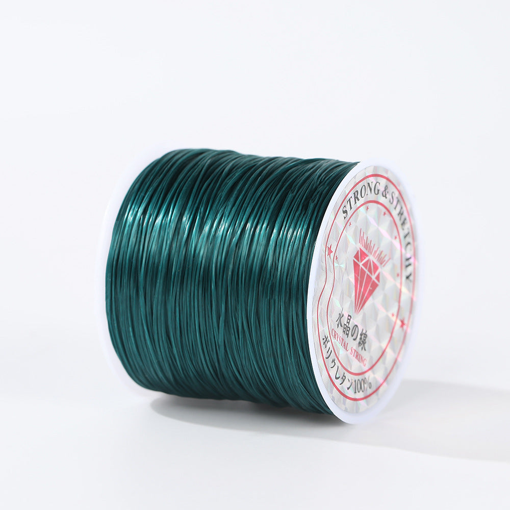 Spool of dark teal-green 0.8mm flat elastic beading cord on its side, white and red diamond label, white background