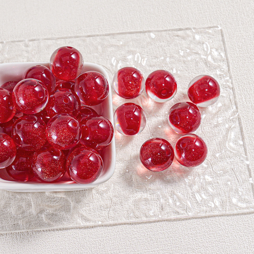 Red glittery round beads in a white dish on a clear textured plate, some sliced open
