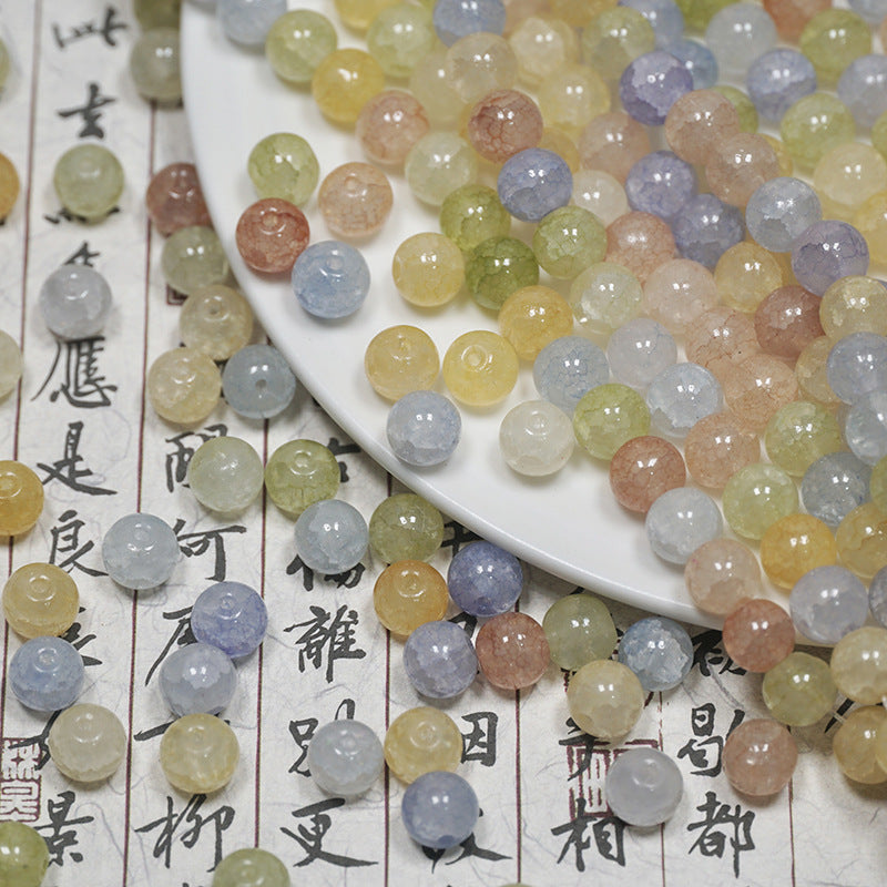 Close-up of pastel multicolor ice-crackle glass beads on calligraphy paper