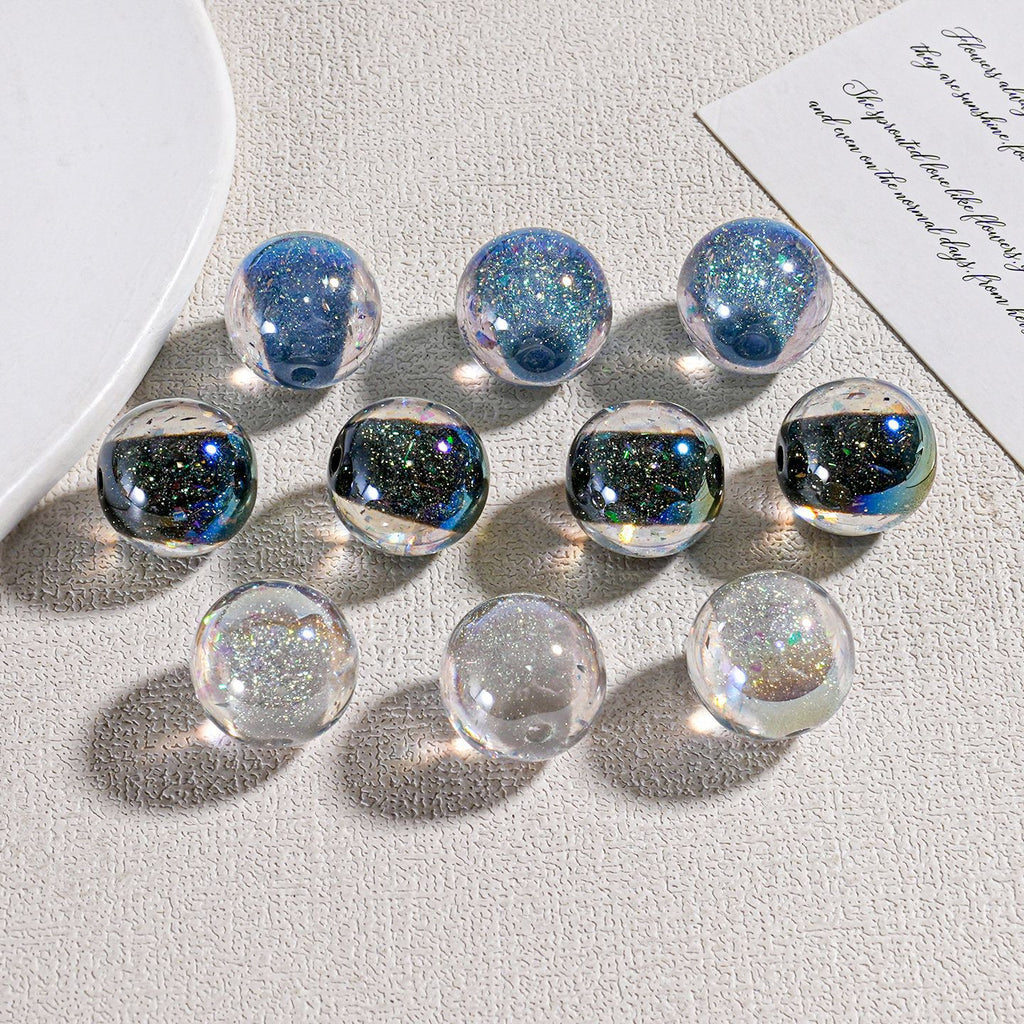 Nine clear candy-core opal-effect resin round beads arranged on a light textured surface
