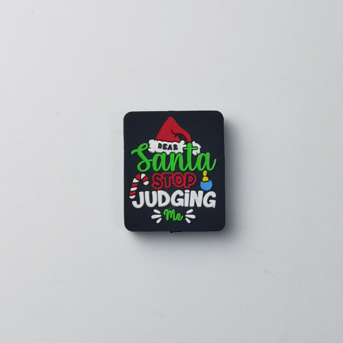 Square black silicone focal bead with 'Dear Santa STOP JUDGING Me' text in green, red and white, small red Santa hat